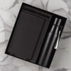 Black notebook and water bottle set in a box on a white background